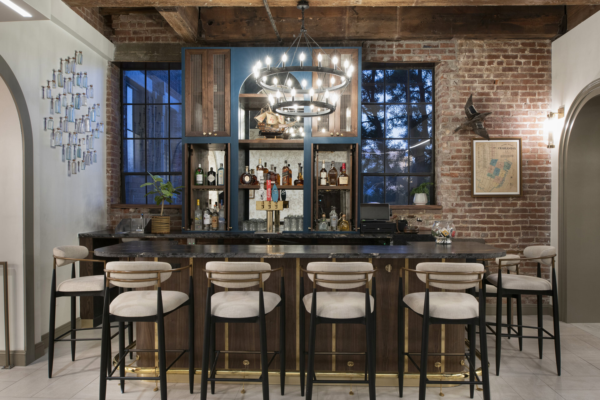 A bar with several high chairs and a chandelier
